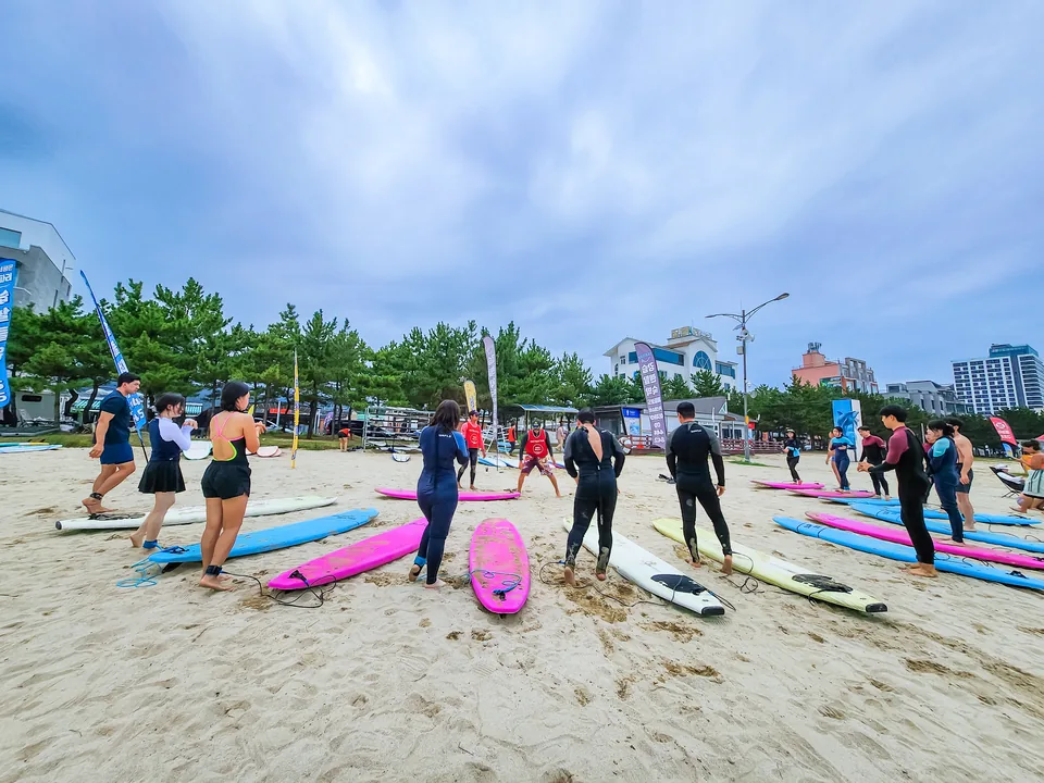 인구해변에서 보드 위 자세를 배우는 서프사이드 그룹 강습